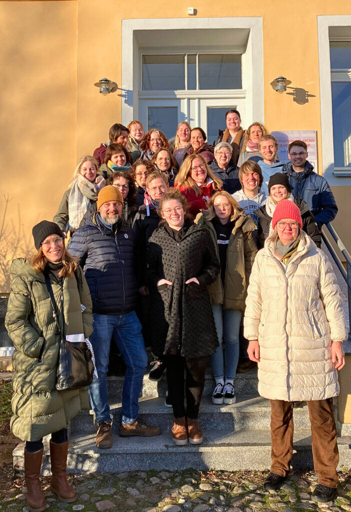 Gruppenfoto der Besucher*innen aus Hannover. Die Teilnehmenden stehen auf der Außentreppe des Archivs.